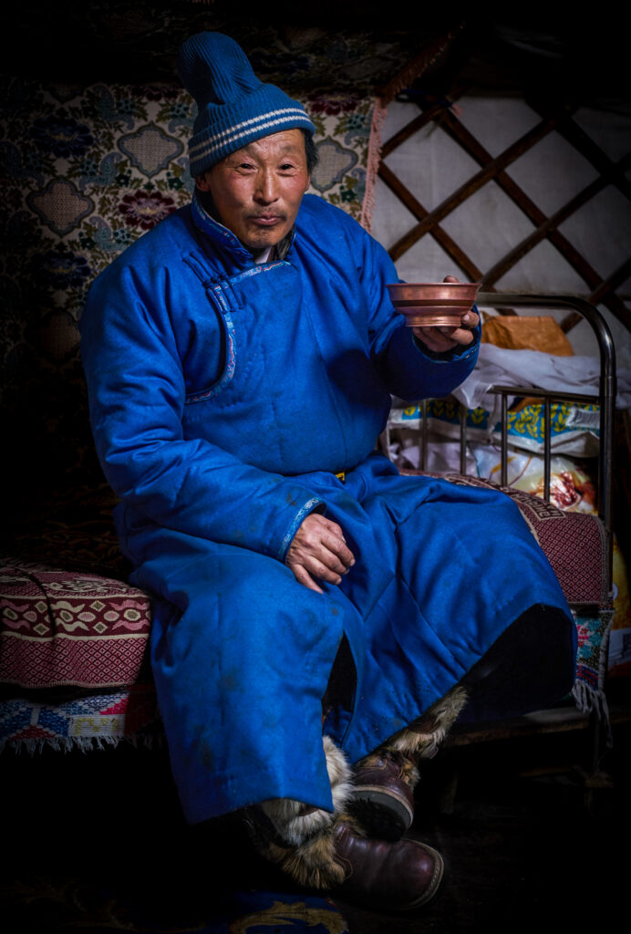A Mongolian nomadic herder comes in from the  -50F cold to share a bowl of araig, a traditional mongolian drink made from fermented horse's milk.
